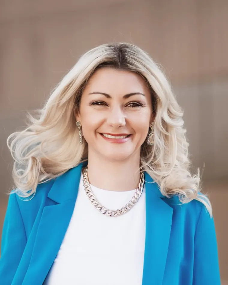 Juliana Käfer, Unternehmerin und Transformationscoach, lächelnd im blauen Blazer